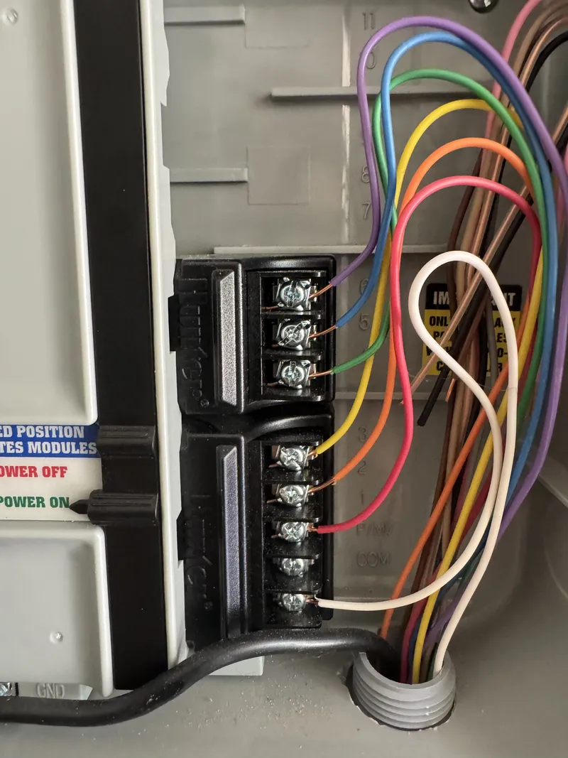 Close-up of irrigation controller modules with colored zone wires at the terminals